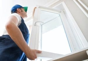 A window technician fitting a new UPVC window frame during a repair in Swindon