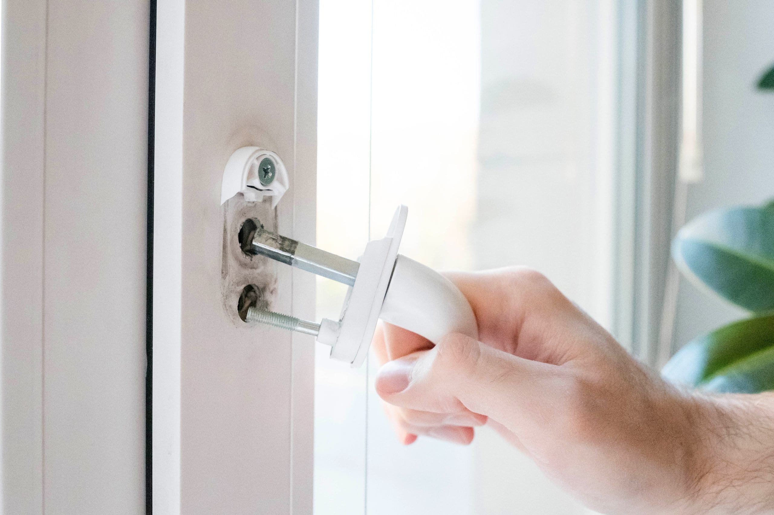 Close-up of a broken UPVC window handle being removed for replacement