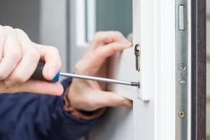 A technician using a screwdriver to repair and replace a UPVC door lock