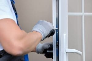 Professional adjusting the lock mechanism on a UPVC door for better alignment